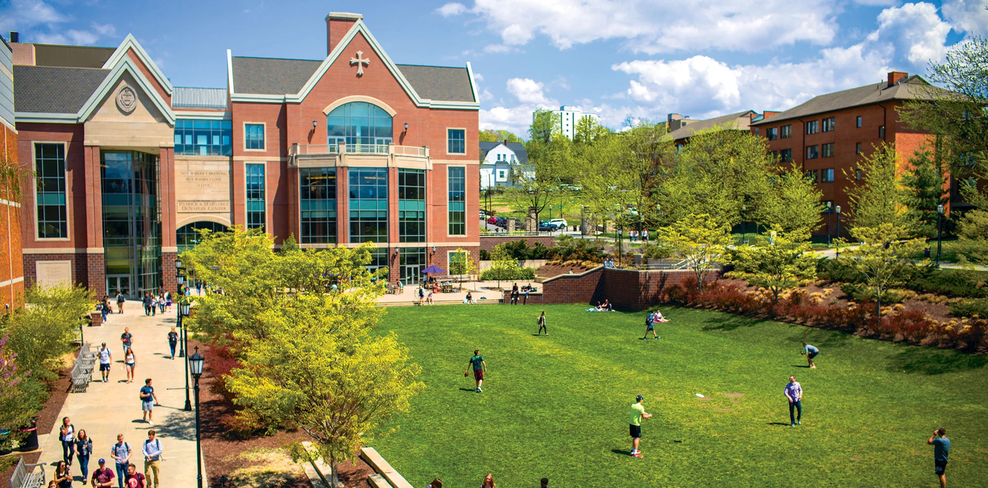  Students on the University's Dionne Green in front of the DeNaples campus building
